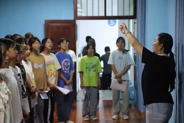 带队教师指导中学生练习齐唱。开云kaiyun官方网站供稿图